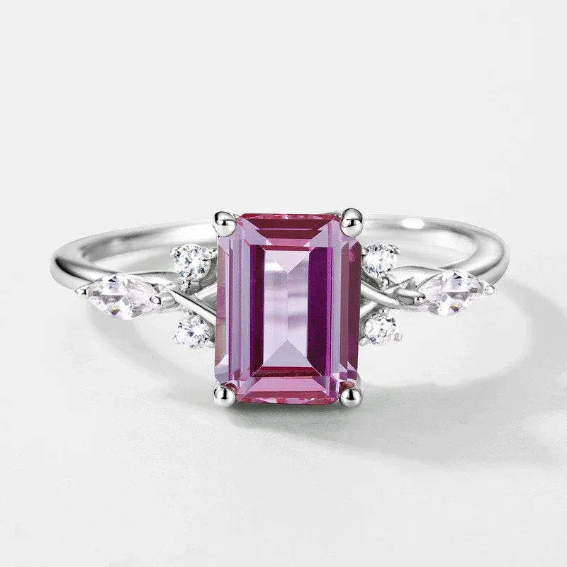 Emerald-cut Alexandrite ring with leaf side accents, pink-toned Alexandrite view under alternate lighting
