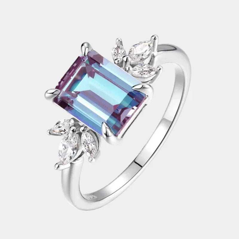 Emerald-cut Alexandrite open ring with leaf side accents, front product view on a white background