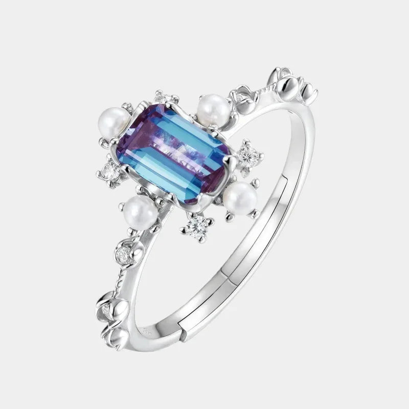 Emerald-cut Alexandrite ring with pearl and clear accents, front product view on a white background