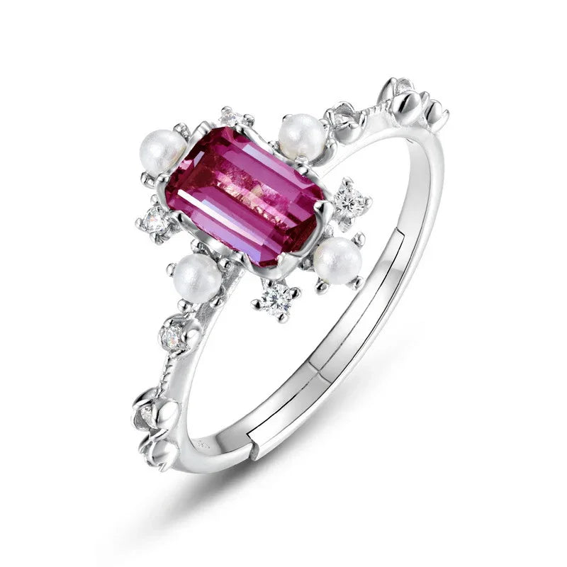 Emerald-cut Alexandrite ring with pearl and clear accents, alternate pink-toned Alexandrite view under alternate lighting
