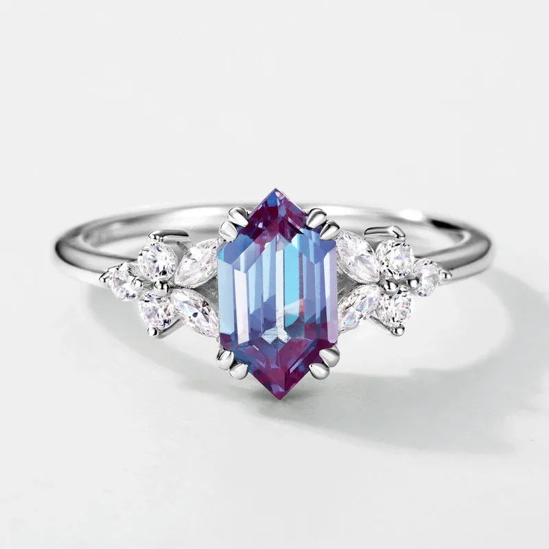 Emerald-cut Alexandrite ring with clear-stone side clusters, center stone close-up on a white background