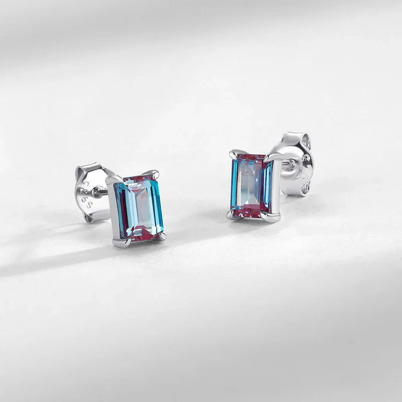 Emerald-cut Alexandrite stud earrings, center stone close-up on a white background