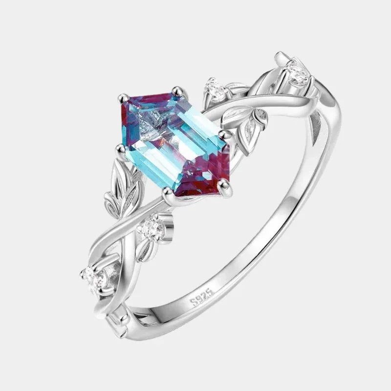 Emerald-cut Alexandrite ring with a vine and leaf band, front product view on a white background
