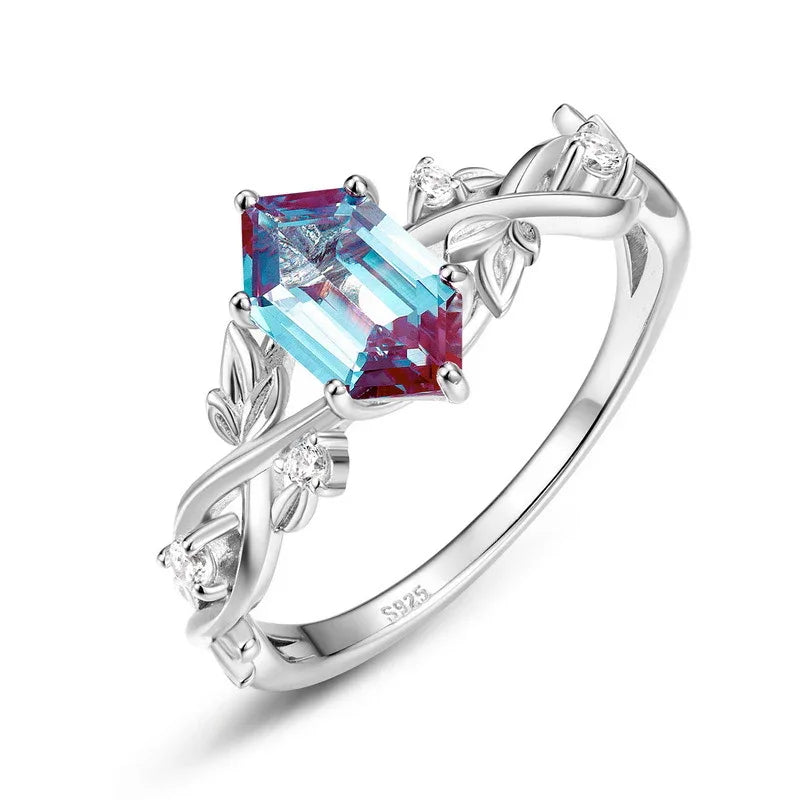 Emerald-cut Alexandrite ring with a vine and leaf band, alternate front product view on a white background