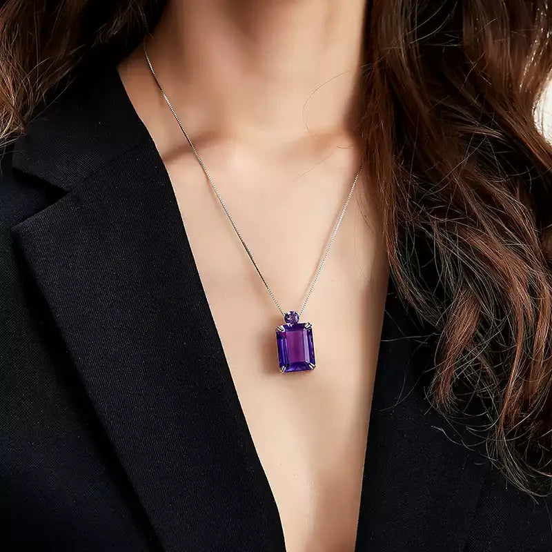 emerald-cut amethyst pendant necklace worn at the neckline in a close-up