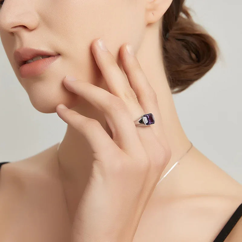 emerald-cut amethyst signet ring worn on the hand in a close-up