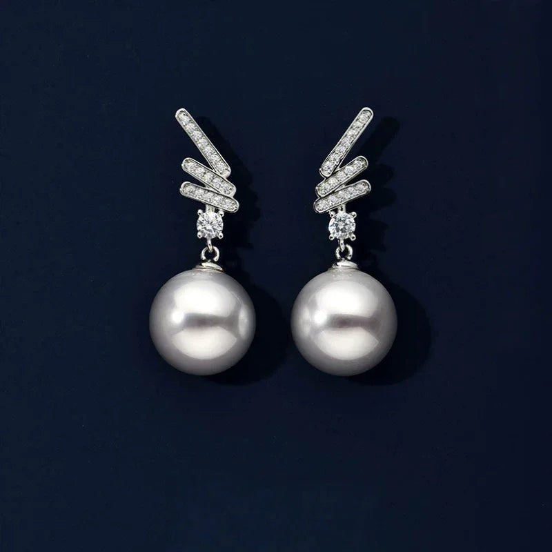 Pearl Wing Drop Earrings — pair displayed on a dark background