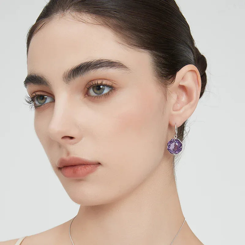 fancy-cut amethyst hook earrings worn on the ear from a second angle
