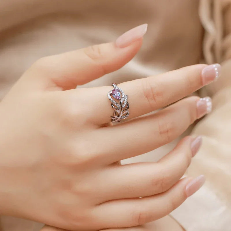 Feather-wrap ring with a Alexandrite and clear accents, shown worn in a close lifestyle view
