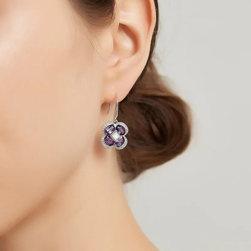 amethyst clover drop earrings worn on the ear in a close-up