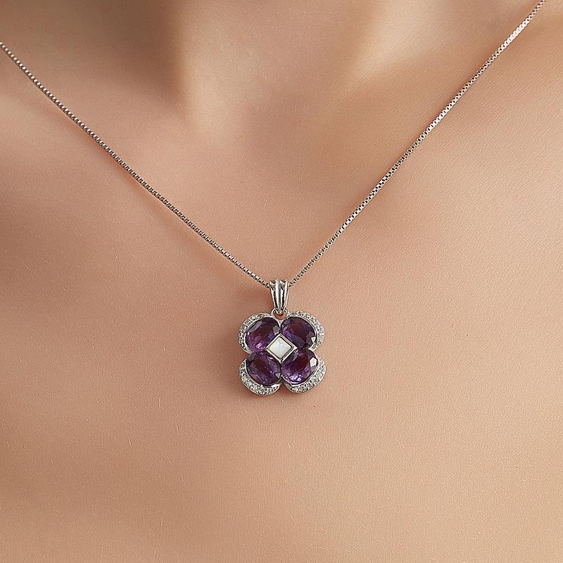 amethyst clover pendant necklace worn at the neckline in a close-up