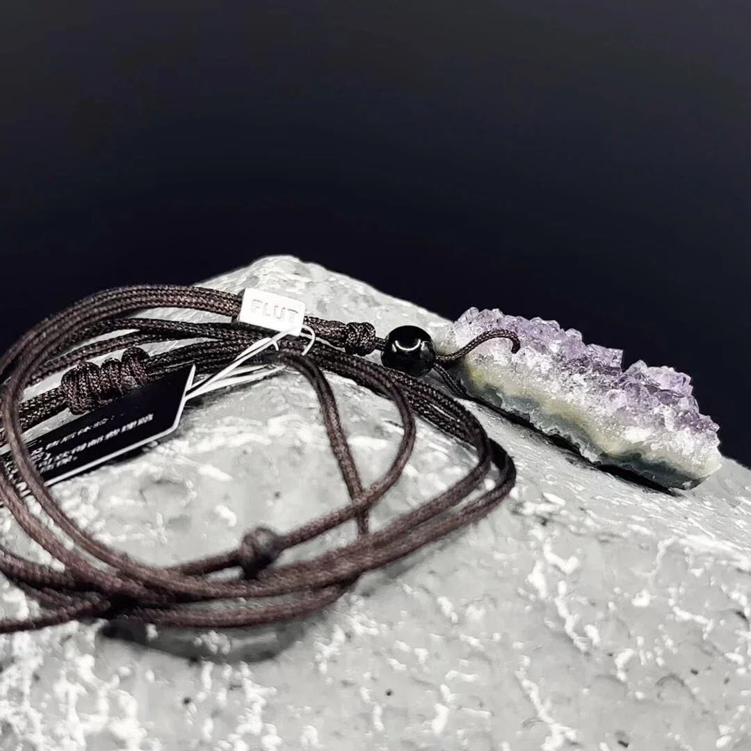amethyst cluster cord necklace crystal cluster and cord on a textured surface