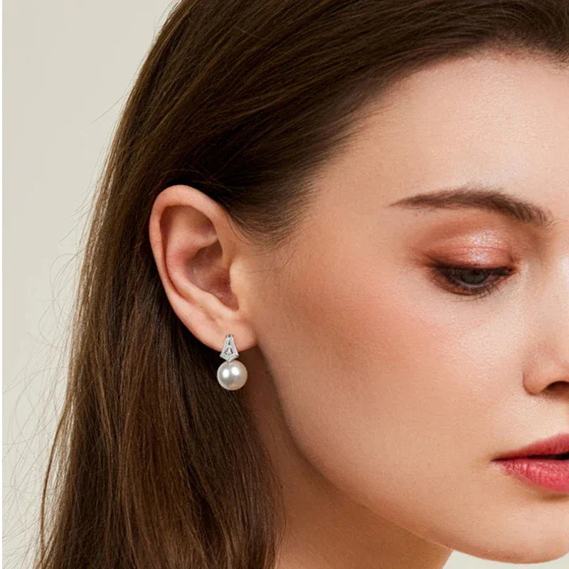 Pearl Drop Earrings with Geometric Fan Detail — left-ear worn portrait with the face angled downward