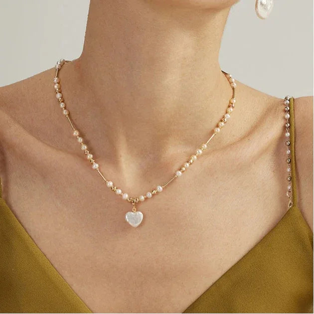 Baroque Pearl Heart Pendant Necklace with Gold Bar Accents — front neckline-worn view over an olive camisole