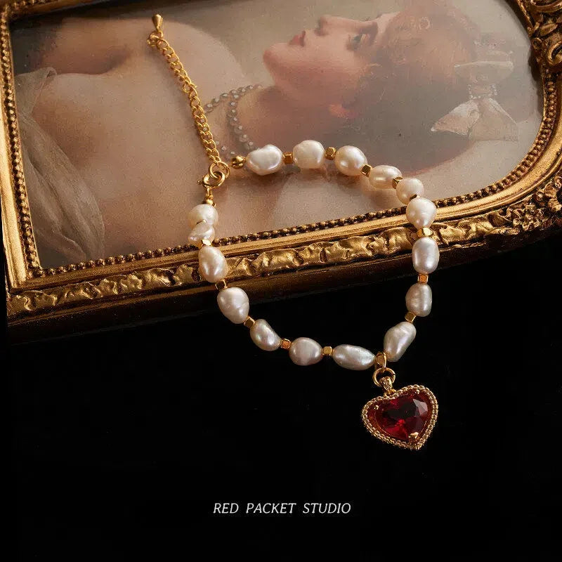 Pearl Bracelet with Red Heart Charm — bracelet arranged on a decorative mirror tray