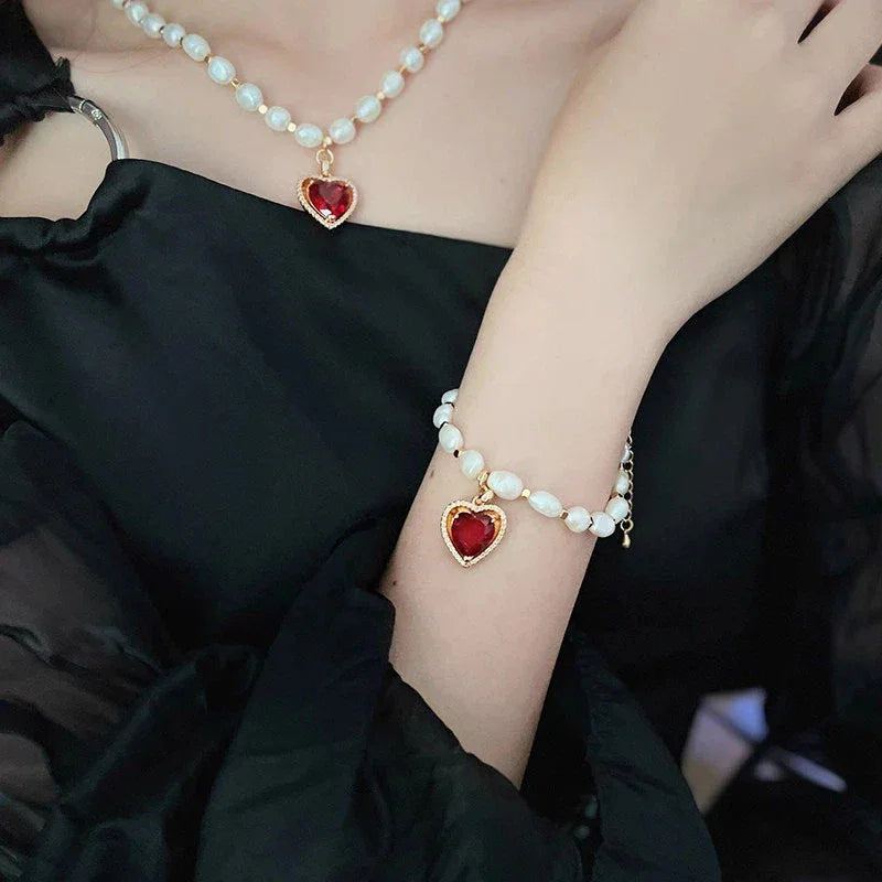Pearl Bracelet with Red Heart Charm — wrist-worn view coordinated with a matching pearl necklace