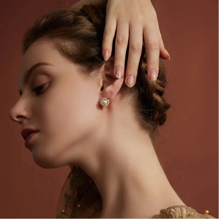 Pearl Halo Stud Earrings — alternate worn portrait with the model's hand above the ear