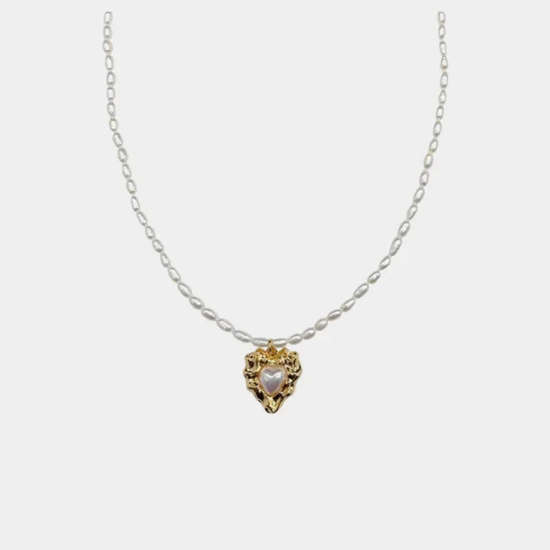 Pearl Heart Pendant Necklace with Gold-Tone Frame — front view of small pearl heart in an ornate gold-tone frame on a silver