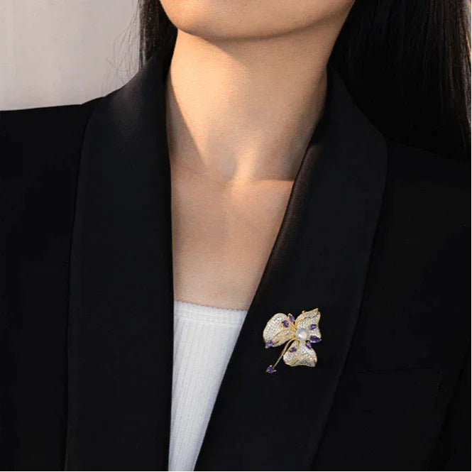 Freshwater Pearl and Cubic Zirconia Bauhinia Brooch — brooch worn on a black blazer