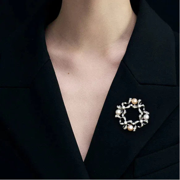 Pearl Bow Wreath Brooch — close black-blazer worn view showing the open center