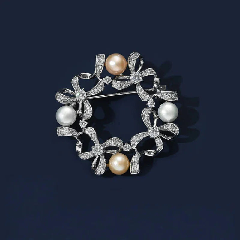 Pearl Bow Wreath Brooch — front product view on a dark background