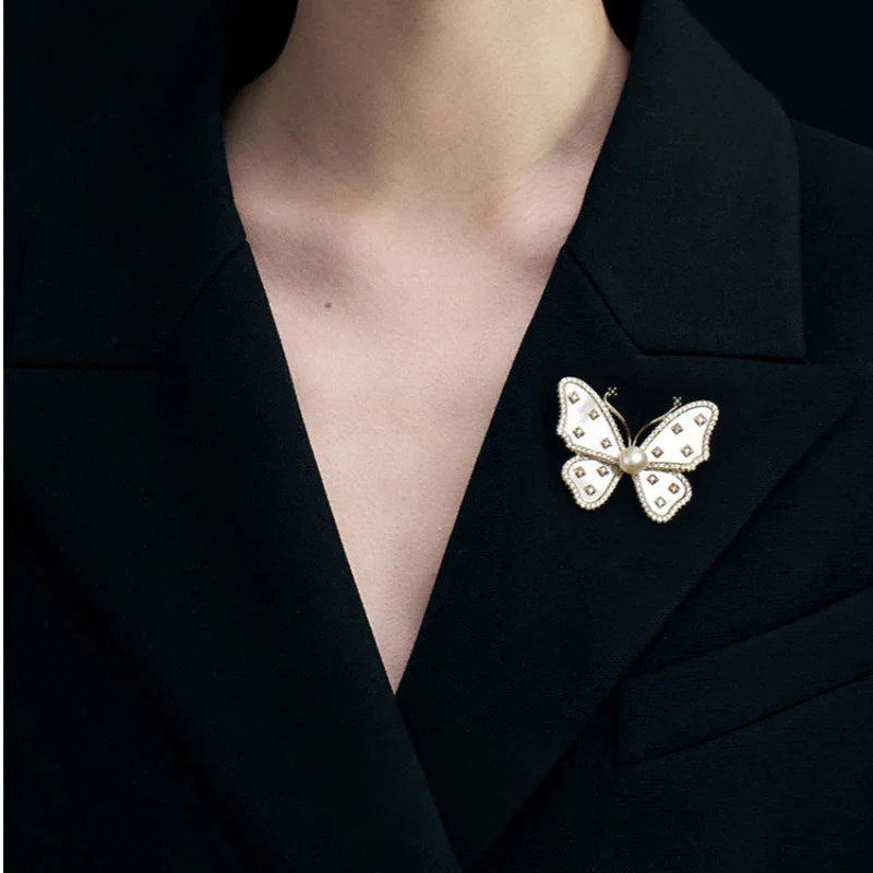 White Mother-of-Pearl Butterfly Brooch with Pearl — close black-blazer worn view showing scale