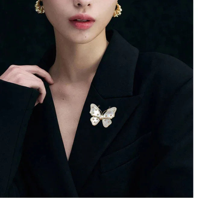 White Mother-of-Pearl Butterfly Brooch with Pearl — model portrait with the brooch pinned on a black blazer