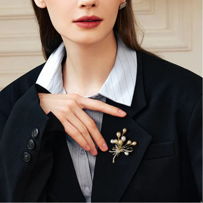 Two-Tone Pearl Spray Bouquet Brooch — waist-up blazer-worn portrait beside the model's hand