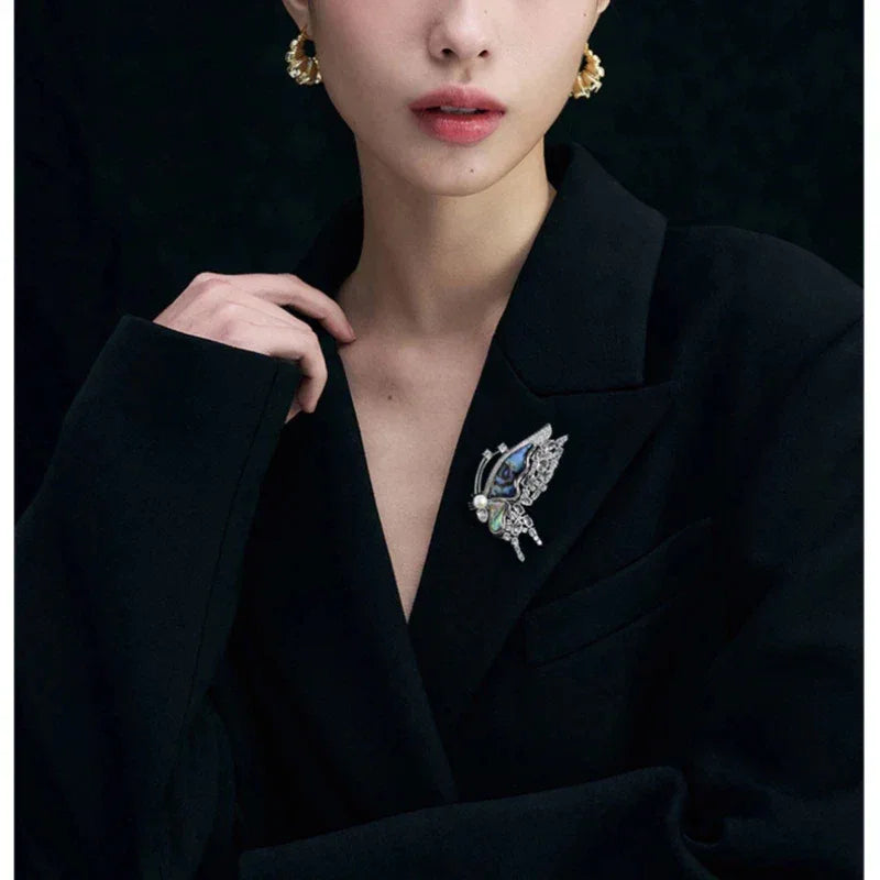 Blue-Green Mother-of-Pearl Butterfly Brooch with Pearl — model portrait with the brooch pinned on a black blazer