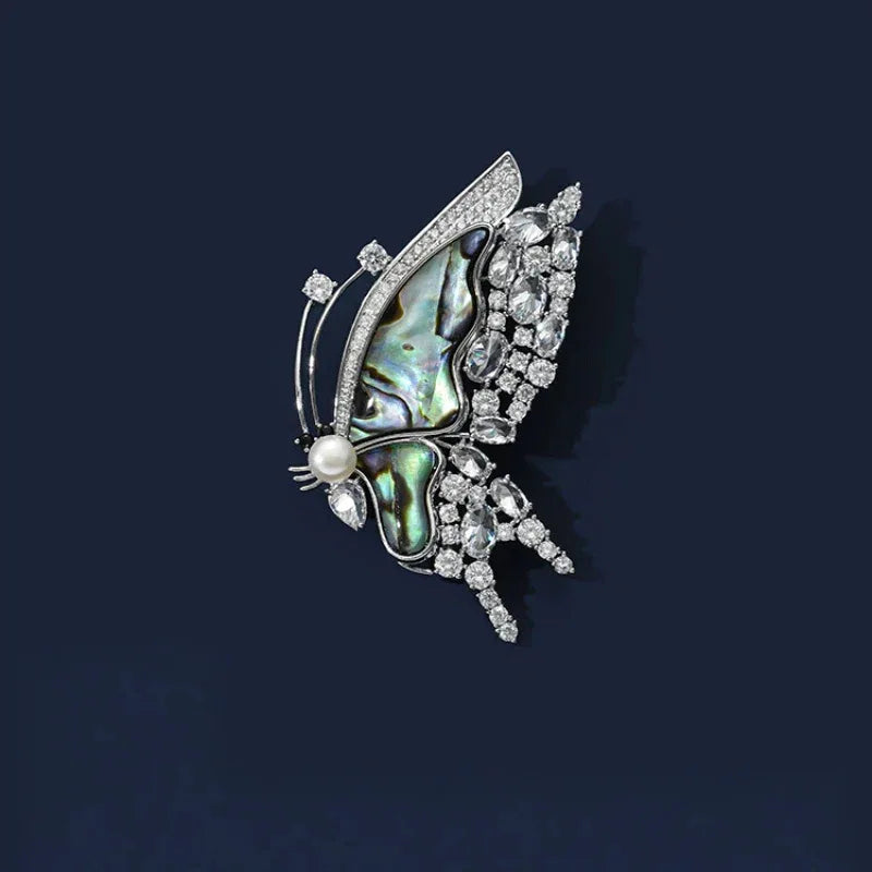 Blue-Green Mother-of-Pearl Butterfly Brooch with Pearl — front product view on a dark background
