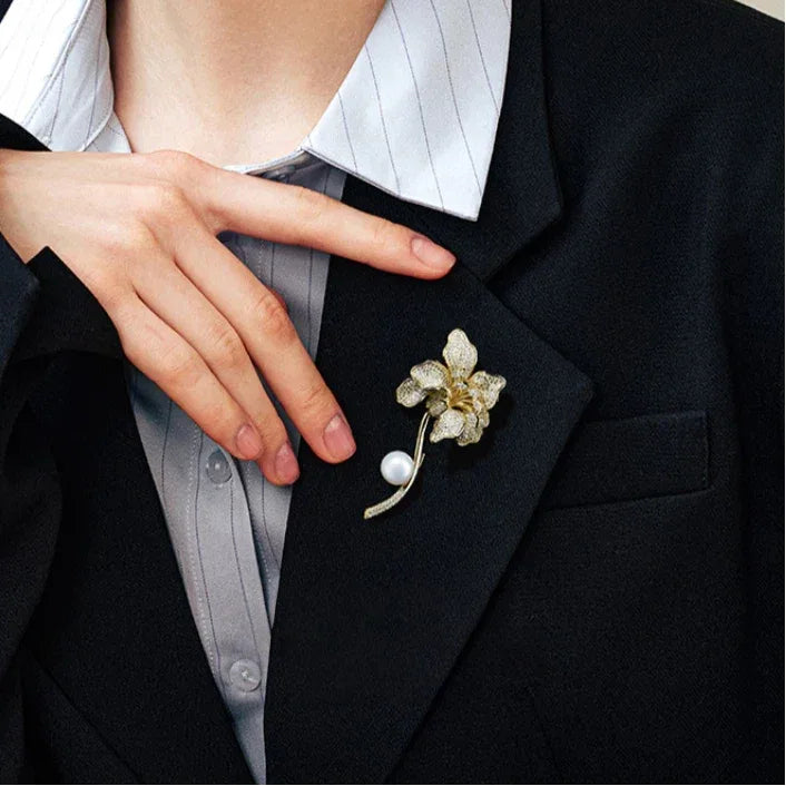 Freshwater Pearl Iris Flower Brooch — waist-up blazer-worn portrait beside the model's hand