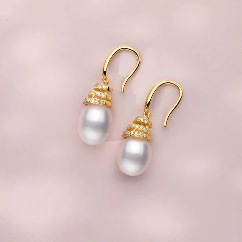 Pearl Beehive Drop Earrings in Gold-Plated S925 Silver — angled pair on a pale pink surface showing the hook wires