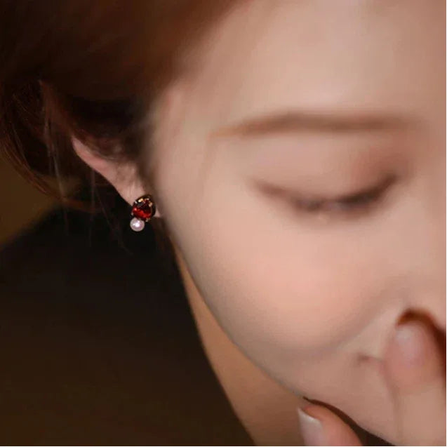 Garnet and Pearl Teardrop Earrings side view held between the fingers