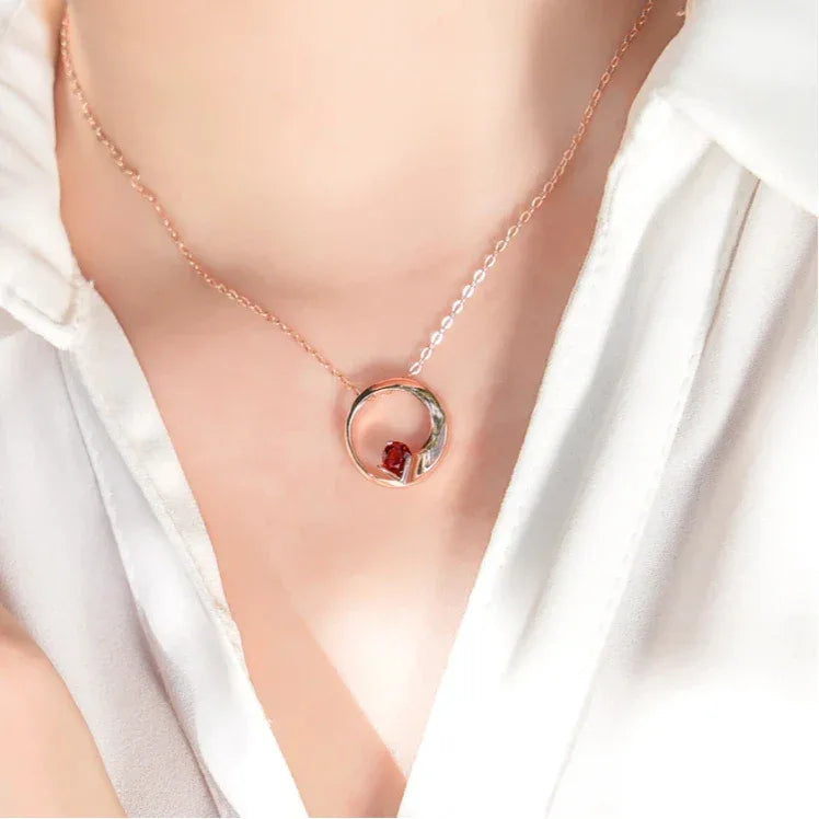 Garnet Circular Pendant Necklace worn at the neckline in a close-up