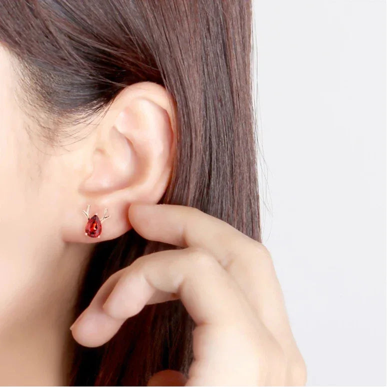 Garnet Deer Stud Earrings worn on the hand in a close-up
