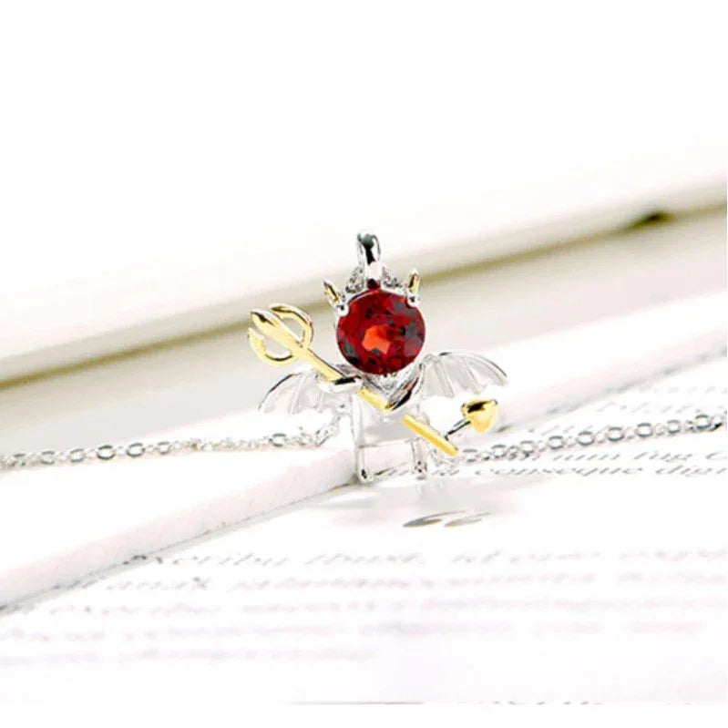 Garnet Devil and Wing Pendant Necklace pendant styled on a jewelry display