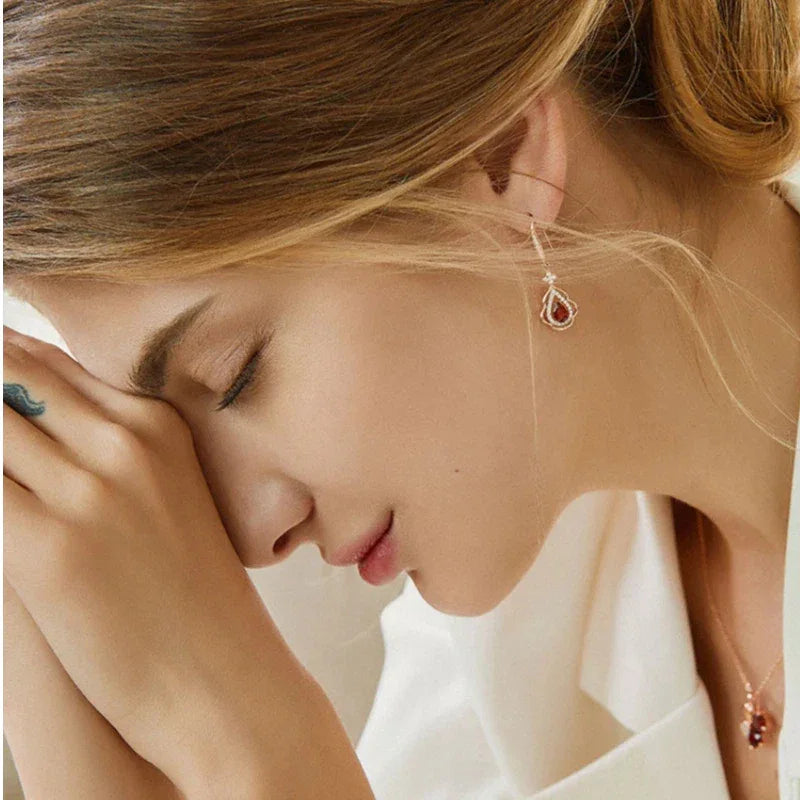 Garnet Filigree Teardrop Earrings side view held between the fingers