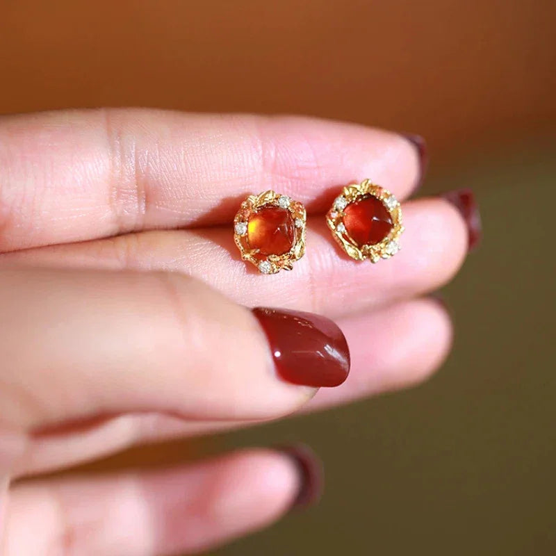 Garnet Floral Halo Stud Earrings angled product detail on a jewelry display