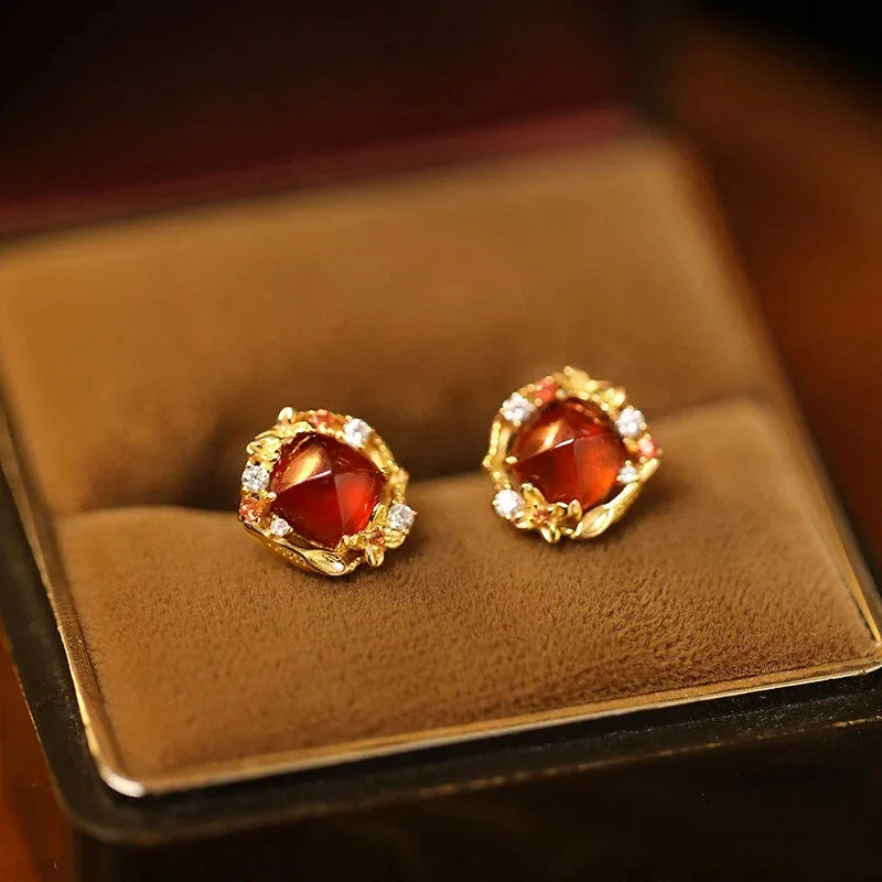 Garnet Floral Halo Stud Earrings side view held between the fingers