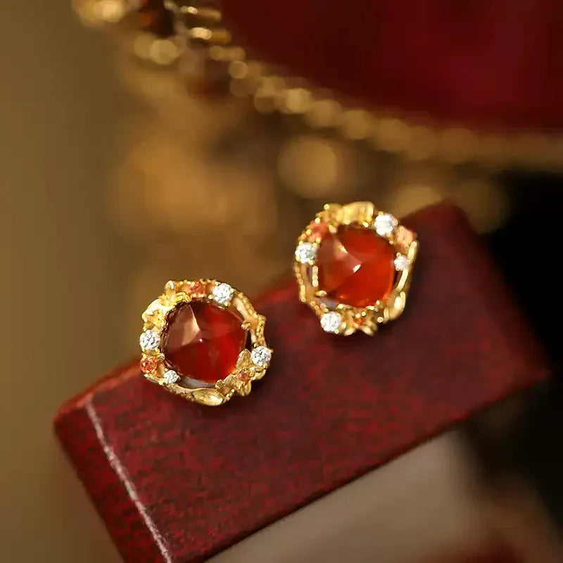 Garnet Floral Halo Stud Earrings worn on the hand from a second angle