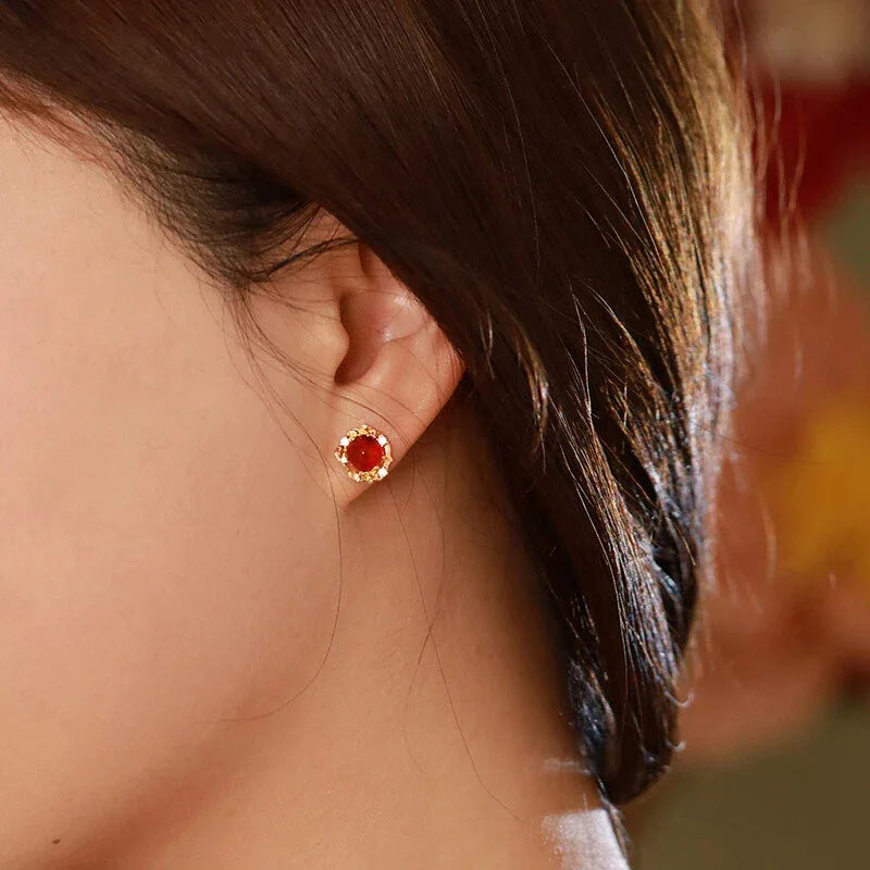 Garnet Floral Halo Stud Earrings worn on the hand in a close-up