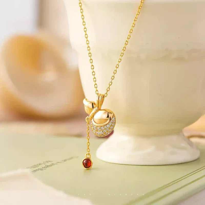 Garnet Gourd Drop Pendant Necklace pendant styled on a jewelry display