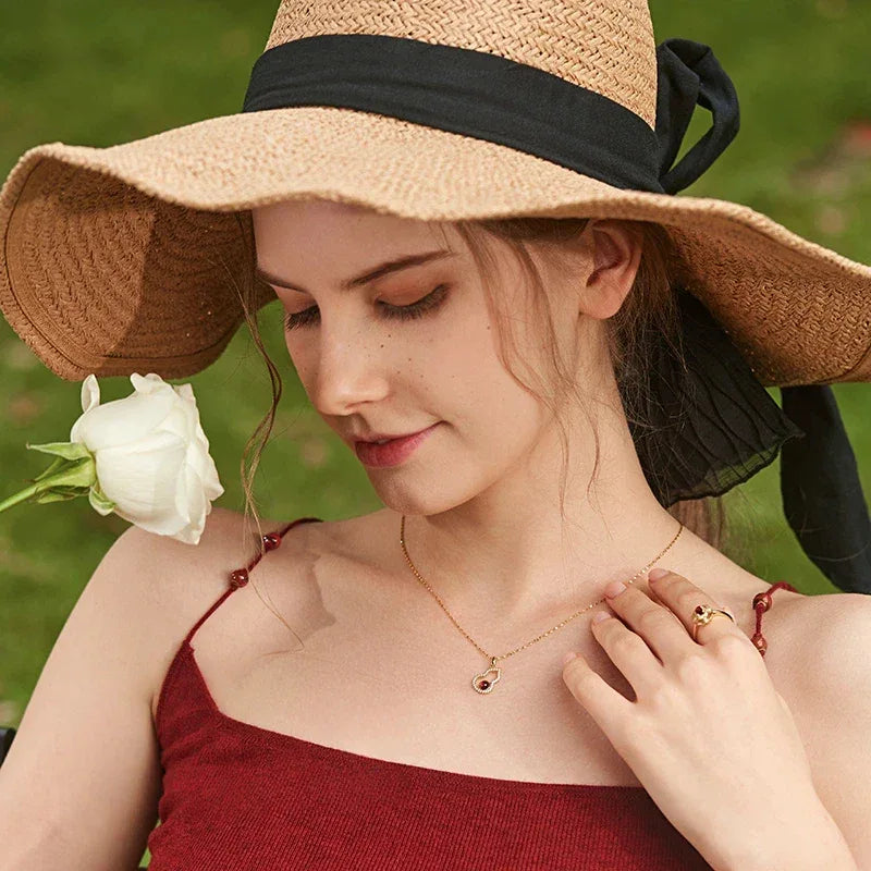 Garnet Gourd Halo Pendant Necklace pendant styled on a jewelry display