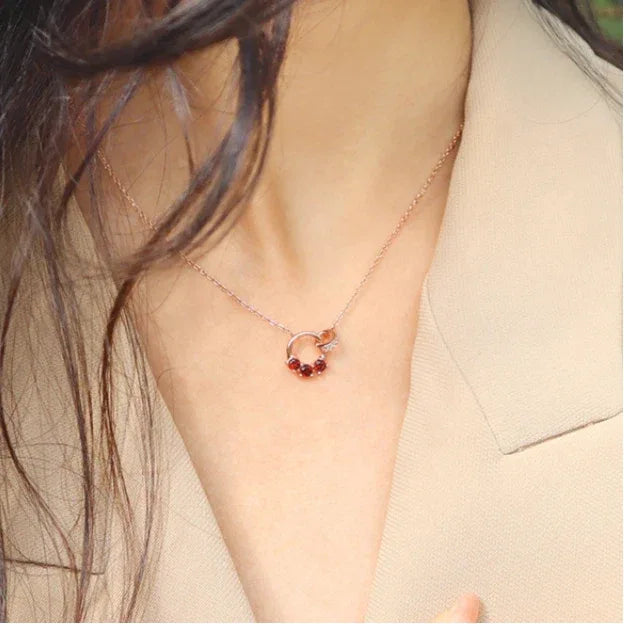 Garnet Interlocking Circle Pendant Necklace pendant styled on a jewelry display