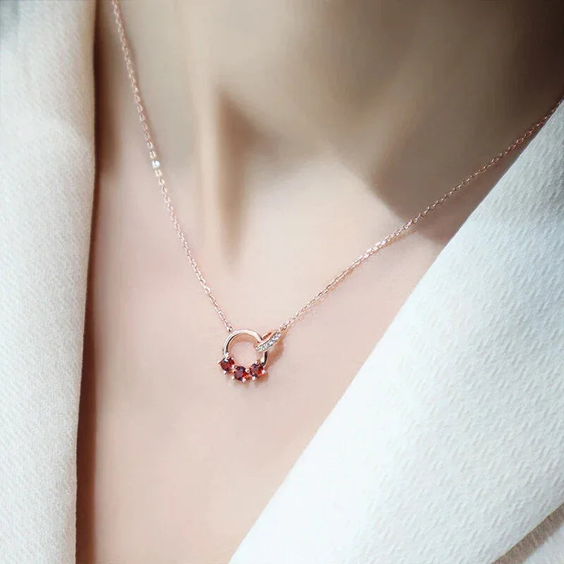 Garnet Interlocking Circle Pendant Necklace worn at the neckline in a close-up