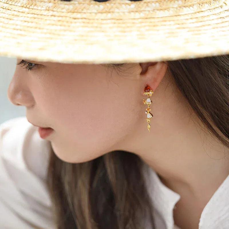 Garnet Leaf Cascade Drop Earrings worn on the hand from a second angle
