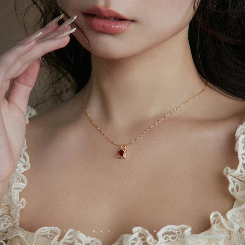 Garnet Padlock Pendant Necklace worn at the neckline in a close-up