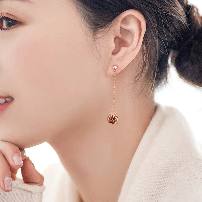 Garnet Pomegranate Threader Earrings worn on the hand in a close-up