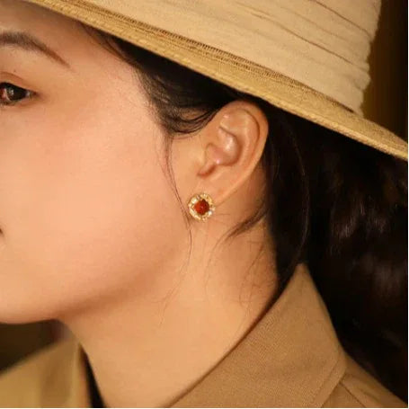 Garnet Rope-Halo Stud Earrings side view held between the fingers