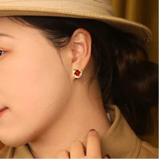 Garnet Rope-Halo Stud Earrings worn on the hand from a second angle